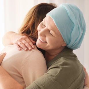 Woman hugging her mother with cancer indoors