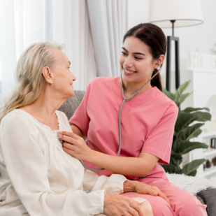 Young professional confident skilled woman doctor visiting old patient lady at home for treatment control care giving. Nurse talking to Caucasian senior patient. Healthcare concept